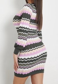 Strikket kjole med et bølget mønster i grøn, pink, hvid og beige. Lange ærmer med ribbet manchetter. Kroppsnær pasform med et tekstureret design.