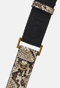 Correa de bolso ajustable con material tejido negro con patrón de piel de serpiente en beige y marrón, acentuada con herrajes dorados y un anillo en D.