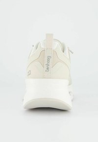 Světlé béžové tenisky s hladkým matným povrchem. Zadní strana má textilní poutko a nenápadné logo. Silná, polstrovaná podrážka pro podporu.