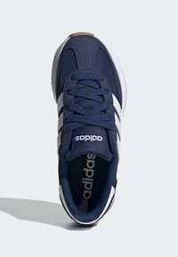 Tamno plavi tenisice s bijelim tri pruga, teksturirani gornji deo, podstavljeni ovratnik i gumeni potplat. Logo prikazan na jeziku i ulošku.