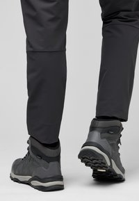 Scarpe da hiking grigie con tessuto testurizzato e dettagli lisci. Suola in gomma robusta con battistrada profondo per una maggiore aderenza. Indossate con pantaloni scuri e aderenti.