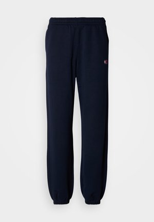 Marineblaue Jogginghosen aus weichem Stoff, mit elastischem Bund und schmal zulaufenden Bündchen. Kleines Logo an der Seite. Einfaches, lässiges Design.