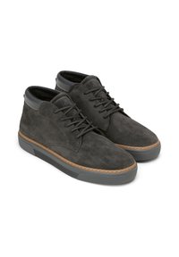 Chaussures décontractées en daim gris foncé à lacets avec des semelles en caoutchouc et des accents de col rembourré noir, présentées côte à côte sur un fond blanc.