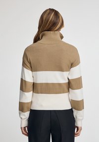 Suéter de cuello alto a rayas marrón y blanco, textura de punto, ajuste relajado, vista trasera, puños y dobladillo de canalé, diseño minimalista.