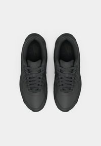 Schwarze Sportschuhe mit einem glatten Lederobermaterial, runder Zehenpartie und traditionellem Schnürsystem. Strukturelle Akzente an der Ferse und der Einlegesohle.