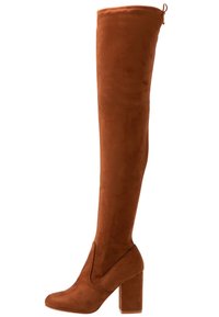 Botte haute marron en suède avec talon bloc et bout arrondi, dotée d'une languette à l'arrière en haut.