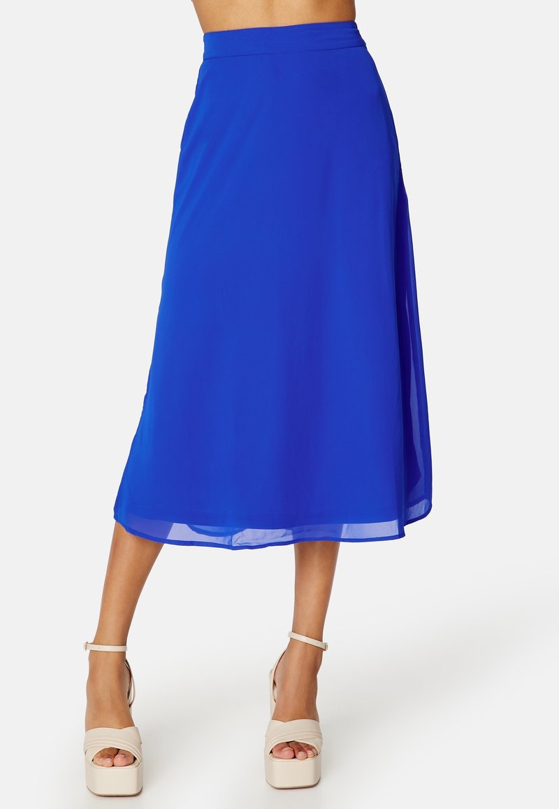 Jupe bleue longueur genou portée avec des sandales à plateforme et talons hauts beige, présentée sur un mannequin de la taille aux pieds sur fond blanc.