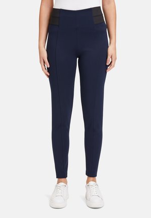 Marineblauwe legging met een hoge tailleband en zwarte paneelaccenten, gemaakt van een rekbaar materiaal, met een slim fit en platte naden.