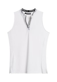 Vit ärmlös topp med hög krage, som har en delvis dragkedja och en svart varumärkesdetalj inuti kragen. Sidokilar för ökad rörelsefrihet.