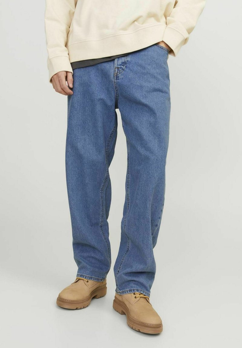 Lys blå denimjeans med en avslappet passform, med fem lommer og rett ben. Kombinert med brune, uformelle sko.