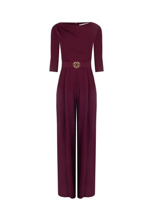 Tuta bordeaux con scollatura a barca, maniche a tre quarti e pantaloni a gamba larga. Presenta un'accento dorato a forma di cerchio in vita.
