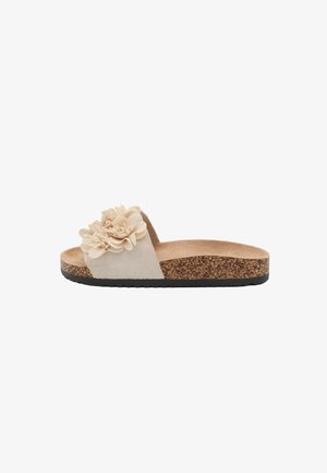 Sandalo beige tipo slide con suola in sughero, battistrada nero e fiori decorativi in tessuto sulla fascia superiore larga.