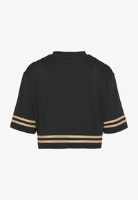 Cropped shirt nera in materiale mesh, con maniche corte e dettagli a strisce dorate sulle maniche. Design con colletto classico.