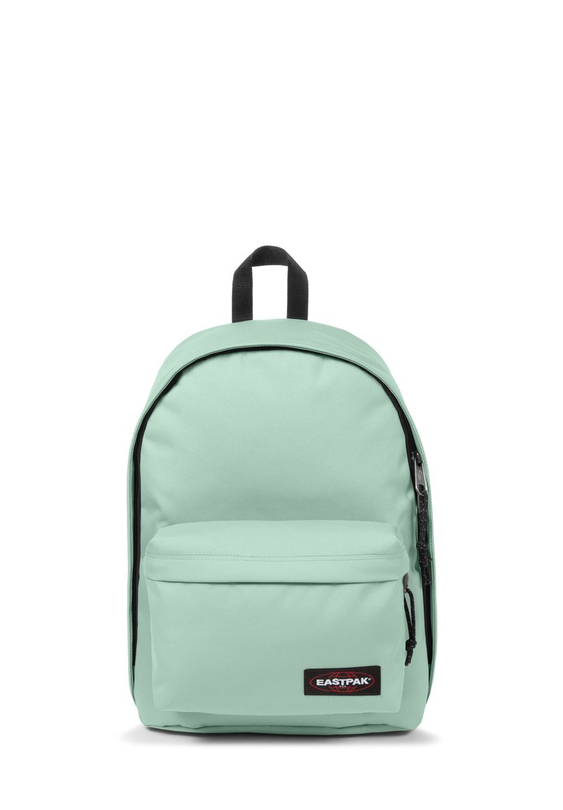 Mochila verde menta claro hecha de tela duradera, con un bolsillo frontal con cremallera, correas acolchadas y un asa en la parte superior. Parche negro con el logotipo exhibido.