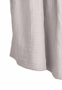 Tissu en muslin gris clair avec une surface douce et texturée. Le tissu tombe librement, avec un ourlet légèrement irrégulier et des plis subtils.