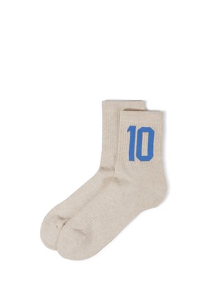 Paar beige Kniestrümpfe mit blau gestrickter Nummer 10 an der Außenseite nahe der oberen Bündchenkante.