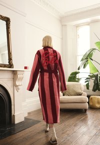 Striped pink and red bathrobe with "Ciao Bella" embroidered on the back, featuring a belt, wide sleeves, and soft texture.