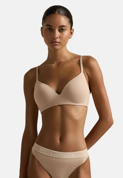 Reggiseno beige senza cuciture con spalline regolabili, tessuto morbido e scollatura a V, abbinato a slip a vita bassa con bordo con logo.