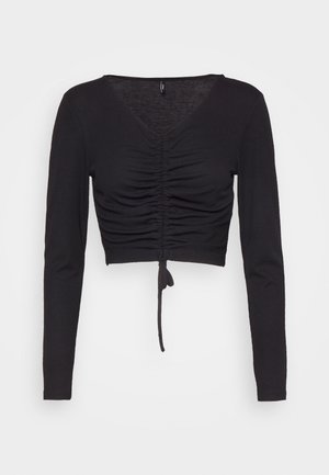 Crop top nero a maniche lunghe in materiale a coste, con scollo a V, dettagli drappeggiati sul davanti e un laccio in vita.
