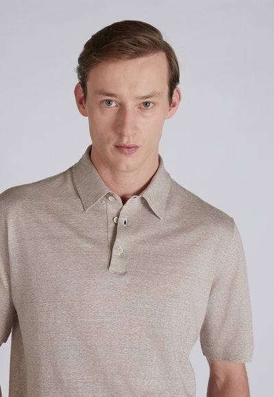JasnoBeżowa koszulka polo z teksturowanej tkaniny, z krótkimi rękawami oraz trzema guzikami w jasnym kolorze.