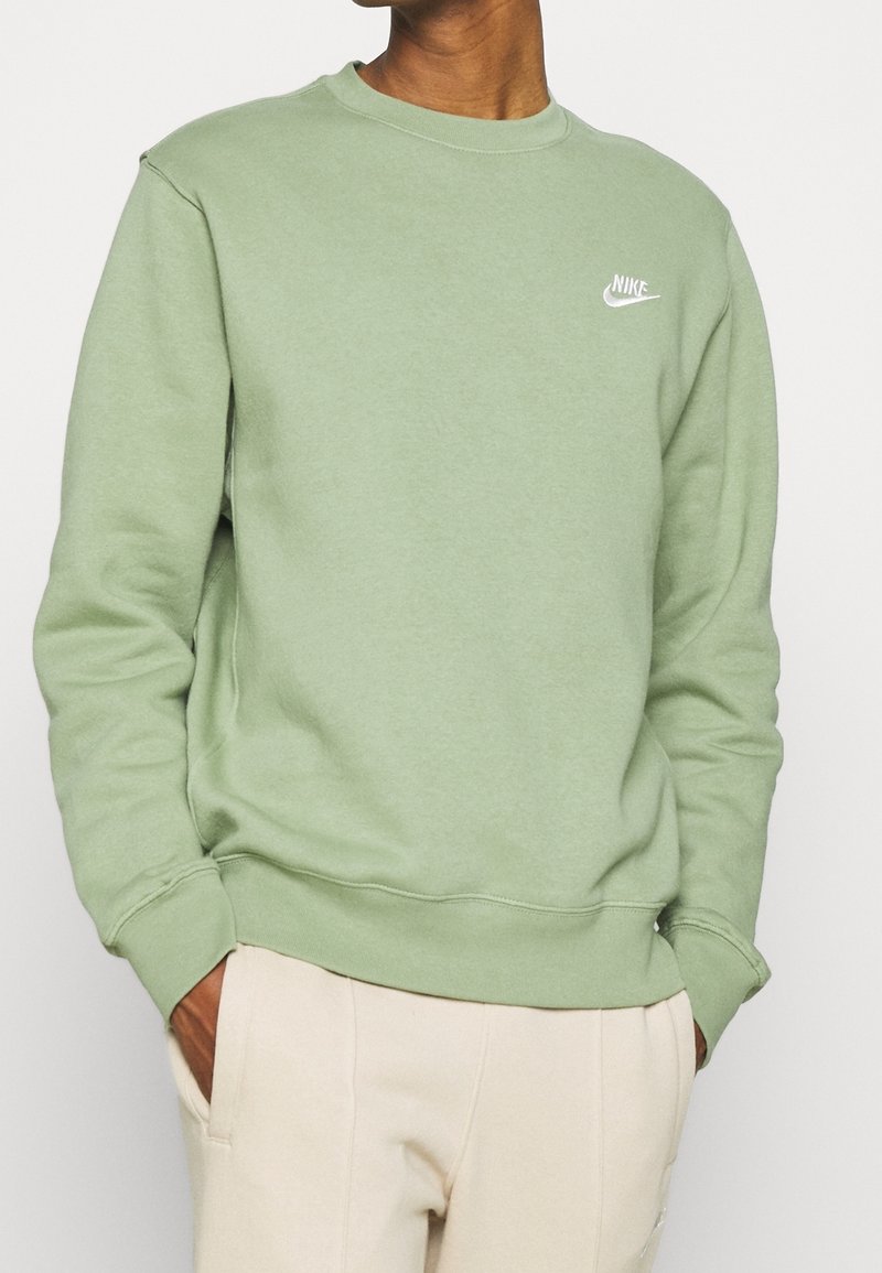Grön sweatshirt i mjukt tyg med rundad halsringning och ribbad mudd. Litet vitt Nike-logotyp på vänster bröst.