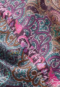 Wielokolorowa tkanina z misternymi wzorami paisley i kwiatowymi w różu, turkusie i złocie na ciemnobrązowym tle. Miękka tekstura.