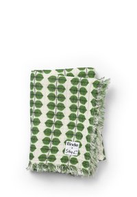 Bomuldsplaid med et grønt bladmønster på en cremefarvet baggrund, med frynser i kanten og et mærke med teksten "Elodie x StigL."