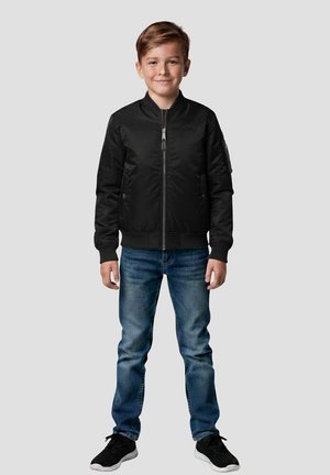 Zwart bomberjack met een ritssluiting aan de voorkant, geribbelde manchetten en zoom, gecombineerd met blauwe jeans en zwarte sneakers. Casual en nauwsluitend ontwerp.