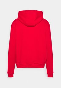 Sweat à capuche rouge vif à manches longues, poignets et taille côtelés, vu de dos sur un fond uni.