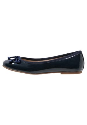 Navy patent ballet flat with a rounded toe, featuring a twisted rope bow detail and a low, flexible sole. Smooth texture with glossy finish.