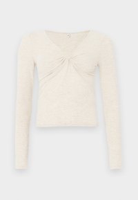 Top de manga larga color crema elaborado en una suave tela texturizada. Presenta un escote en V y un detalle retorcido en el centro. Diseño cropped.