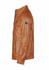 La chaqueta de cuero marrón presenta un cierre de cremallera en el frente, hombros acolchados, bolsillos laterales y un parche redondo negro con el logo en la parte superior del brazo.