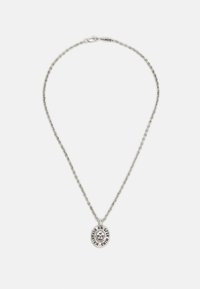 Colar de prata com um pendente oval, adornado com desenhos intrincados e texto, suspenso numa corrente delicada com fecho tipo lagosta.