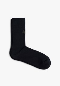 Calcetines negros de canalé con una textura suave y puntera reforzada. Presenta un sutil logo en script de contraste en el lateral.