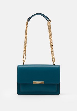 Sac à main en cuir bleu sarcelle avec une bandoulière en chaîne dorée et une plaque rectangulaire dorée portant l’inscription Michael Kors sur le rabat avant.