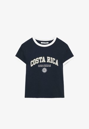 T-shirt bleu marine à manches courtes avec col et poignets blancs, texte « COSTA RICA » et motif soleil du club sportif sur le devant.