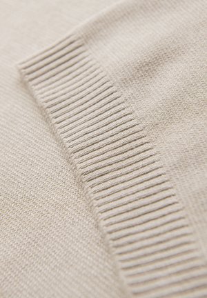 Tessuto a maglia beige con una texture liscia, caratterizzato da una sezione a coste lungo un bordo, che enfatizza il suo motivo sottile e il materiale morbido.