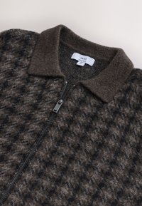 Veste zippée marron à motifs, fabriquée en tissu mélangé de laine, avec un col doux et une fermeture éclair métallique dotée d'une languette rectangulaire.