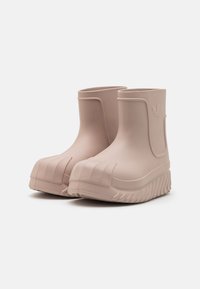 Botas de tobillo de goma rosas con acabado texturizado, que presentan una puntera redonda, suela acanalada y un detalle de logo en relieve en el lateral.