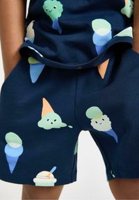 Marinblå bomullsshorts med en lekfull glassdesign i pastellfärger, med inslag av grönt, orange och blått. Mjuk textur.