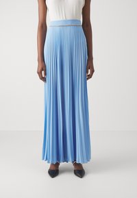 Plisserte maxiskjørt i lys blå, med et liv med perledetaljer. Stoffet har en glatt tekstur og flyter elegant.