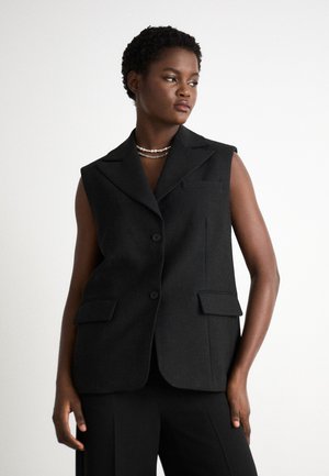 Blazer senza maniche nero con collare a punta, due tasche anteriori e chiusura con bottone. Tessuto liscio e vestibilità su misura.