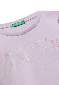 Fialové tričko s nápisem "United Colors of Benetton" v mnohobarevném, texturovaném vyšívání. Žebrovaný výstřih a měkká tkanina.