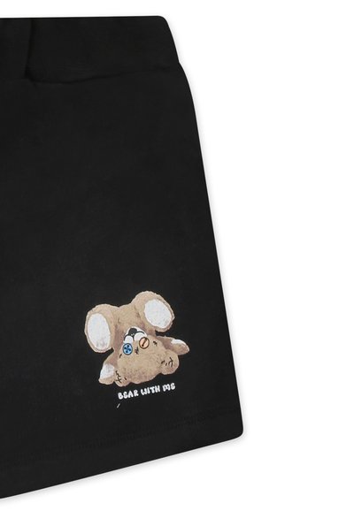 Tessuto nero con un design di un animale di peluche cartoonesco marrone, con grandi orecchie e bottoni blu e arancioni, il testo dice "Bear with me."