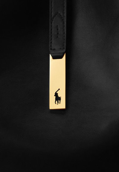 Bracelet en cuir noir avec une plaque rectangulaire dorée représentant une silhouette noire d’un joueur de polo à cheval.