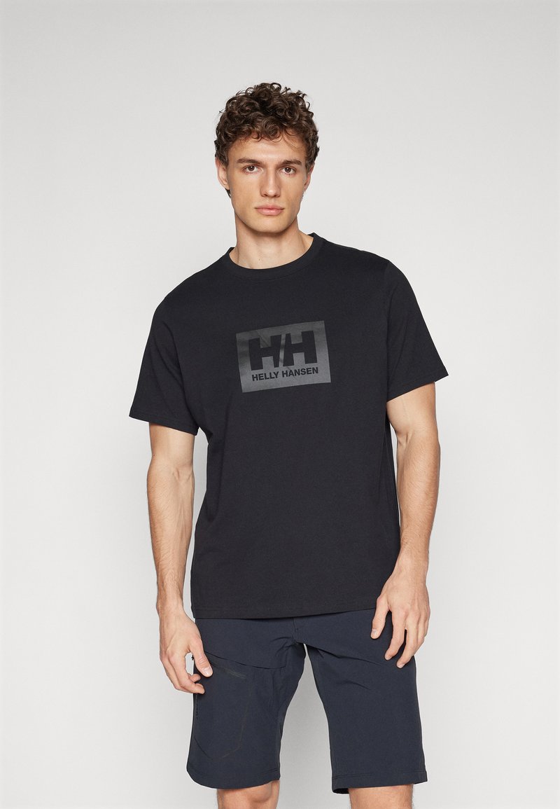 Tricou din bumbac negru, cu guler rotund și mâneci scurte, având un logo mare Helly Hansen în culorile negru și gri pe față.