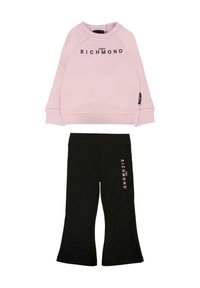 Felpa rosa con polsini a coste e logo in testo nero, abbinata a pantaloni flared neri con stampa del logo rosa lungo il lato.