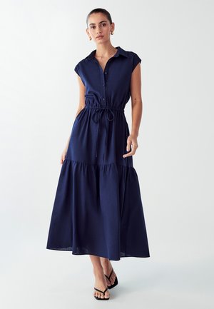 Navy blue, button-down dress with short sleeves, tie waist, and tiered skirt. Lightweight fabric, ankle-length, and relaxed fit.