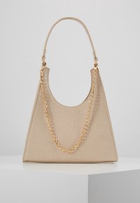 Beżowa torebka z bejcowanej skóry ekologicznej o fakturze krokodyla, kanciastym kształcie i złotym łańcuszkiem na uchwycie.