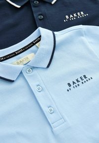 Svetlomodré a námorníckomodré polo tričká s kontrastnými goliermi, dvoma gombíkmi a vyšívanými logami "BAKER by TED BAKER". Textúrovaná tkanina.